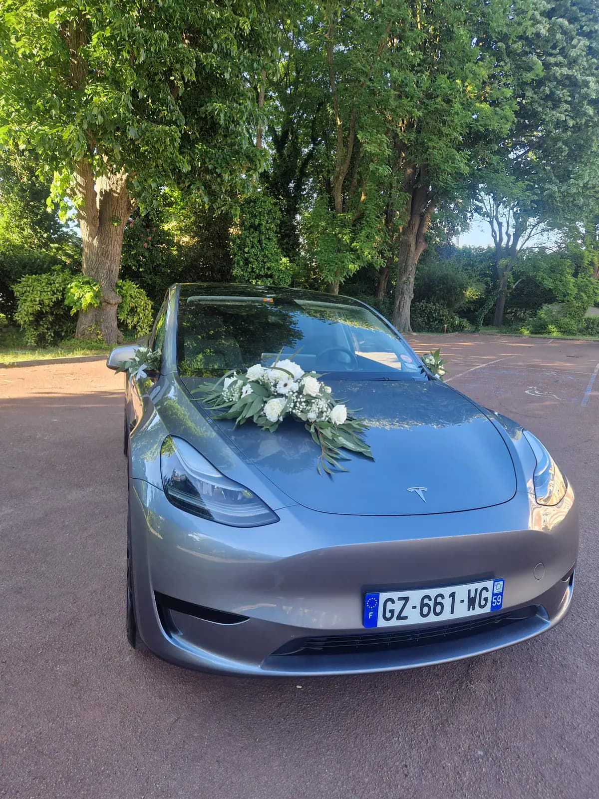 Tesla Model Y grise décorée de fleurs blanches, voiture de mariage avec chauffeur